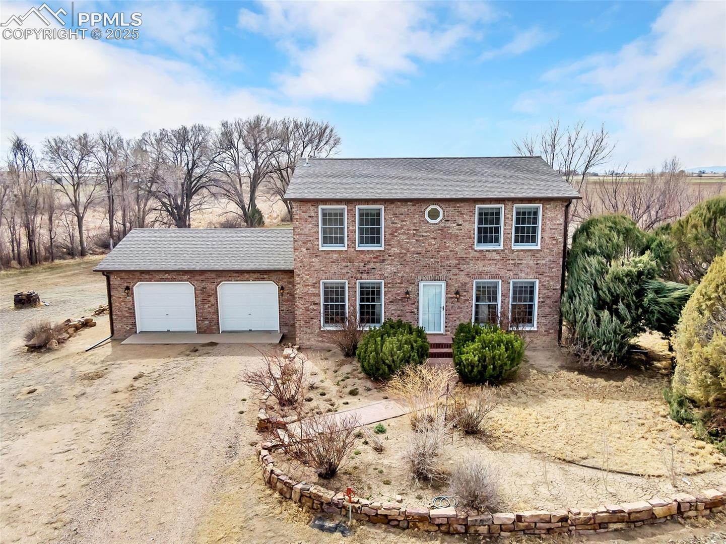 3954 County Rd KK 75 Fowler, CO 81039 - Photo 1 of 41 Colonial inspired home with brick siding, a garage, driveway, and roof with shingles