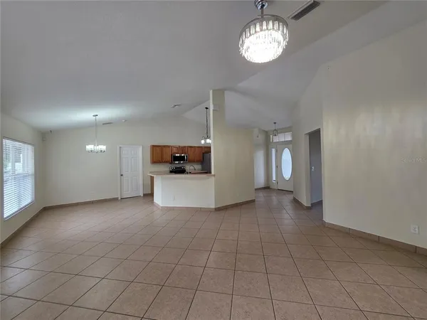 an empty room with kitchen and windows