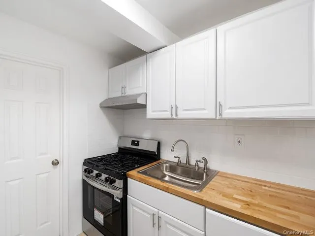 a kitchen with granite countertop white cabinets and stainless steel appliances