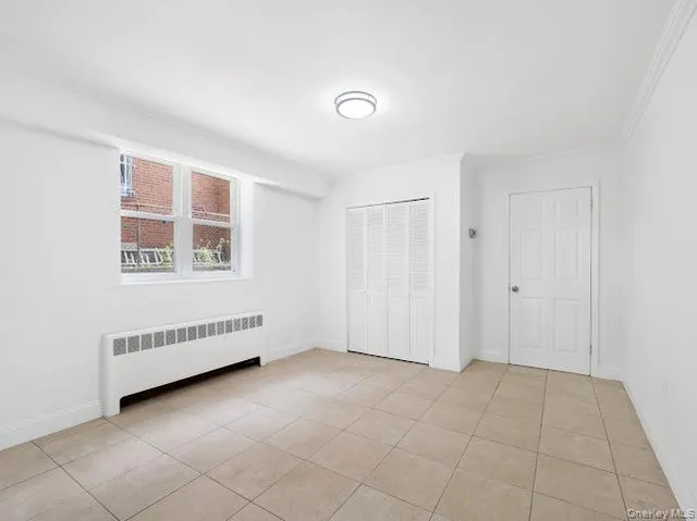 an empty room with windows and closet