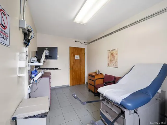 a living room with furniture a flat screen tv and kitchen view