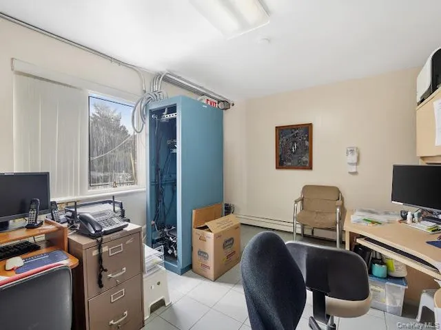 a view of a workspace with furniture and a window
