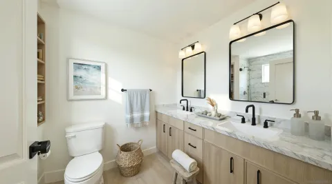 a bathroom with a granite countertop toilet sink and a mirror
