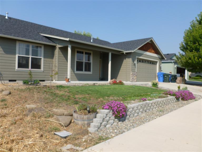 900 Win Way Eagle Point, OR 97524 - Photo 1 of 9 a front view of a house with a yard and garage