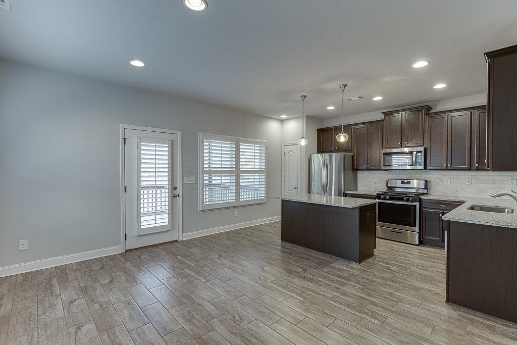 567 Lillian Way Jefferson, GA 30549 - Photo 11 of 80 a large kitchen with stainless steel appliances granite countertop a stove a sink a refrigerator and a large window