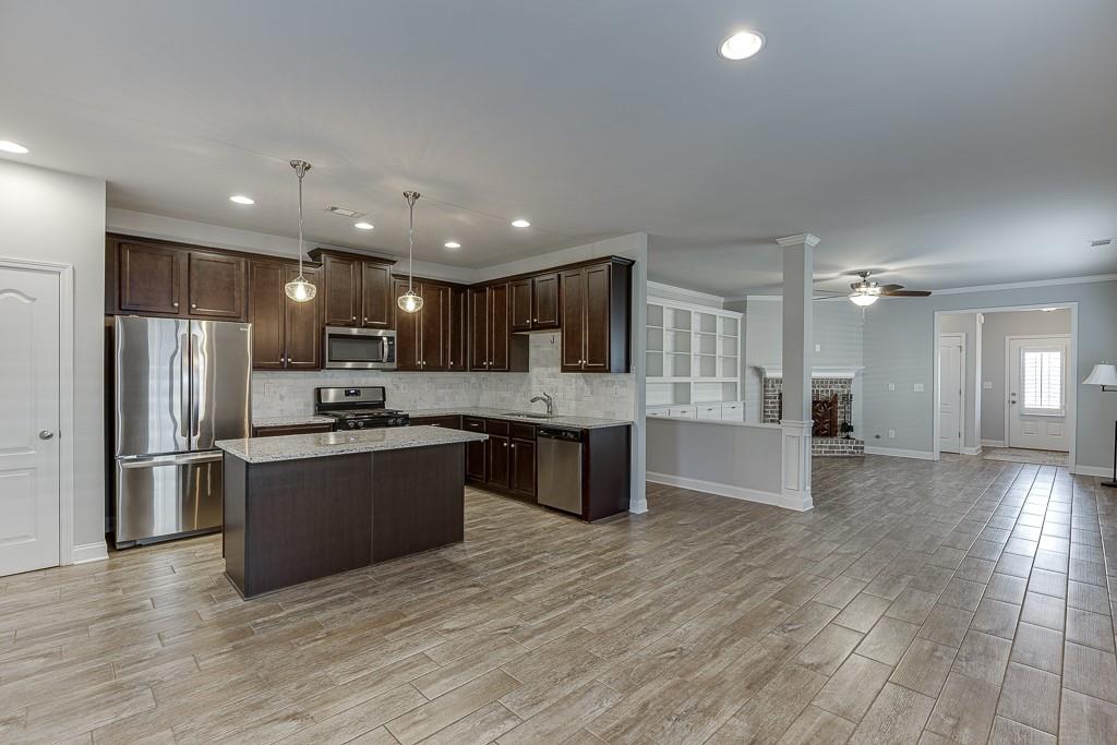 567 Lillian Way Jefferson, GA 30549 - Photo 12 of 80 a large kitchen with stainless steel appliances kitchen island a large counter top and a stove top oven