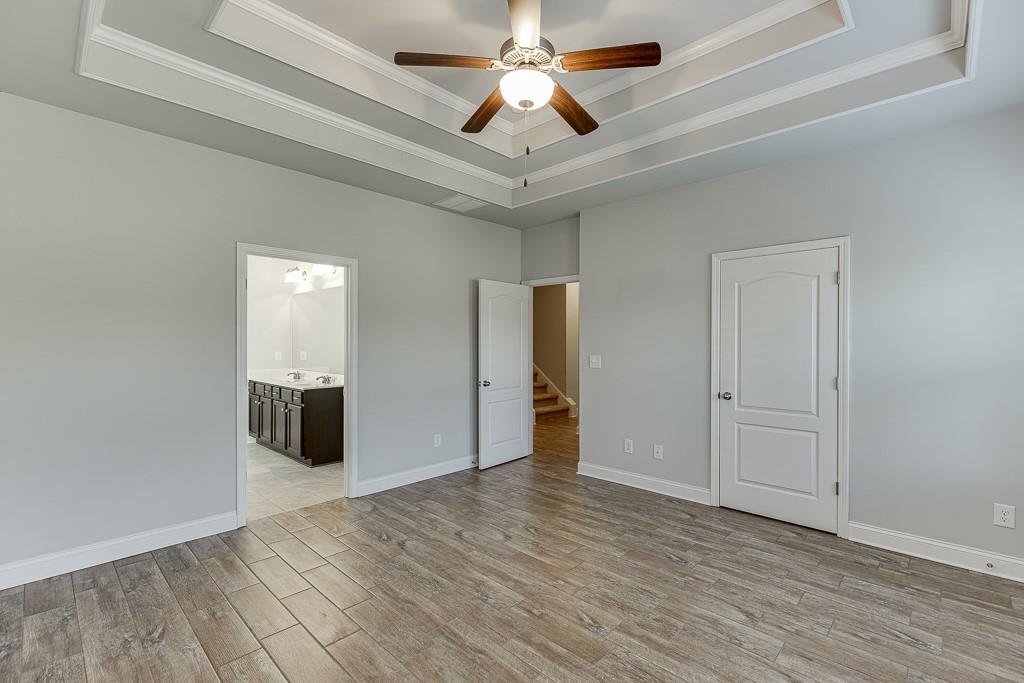 567 Lillian Way Jefferson, GA 30549 - Photo 28 of 80 an empty room with wooden floor and ceiling fan