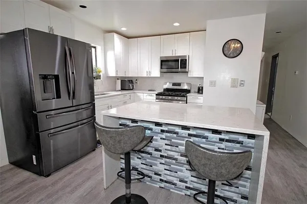 a kitchen with stainless steel appliances granite countertop a sink stove refrigerator and microwave