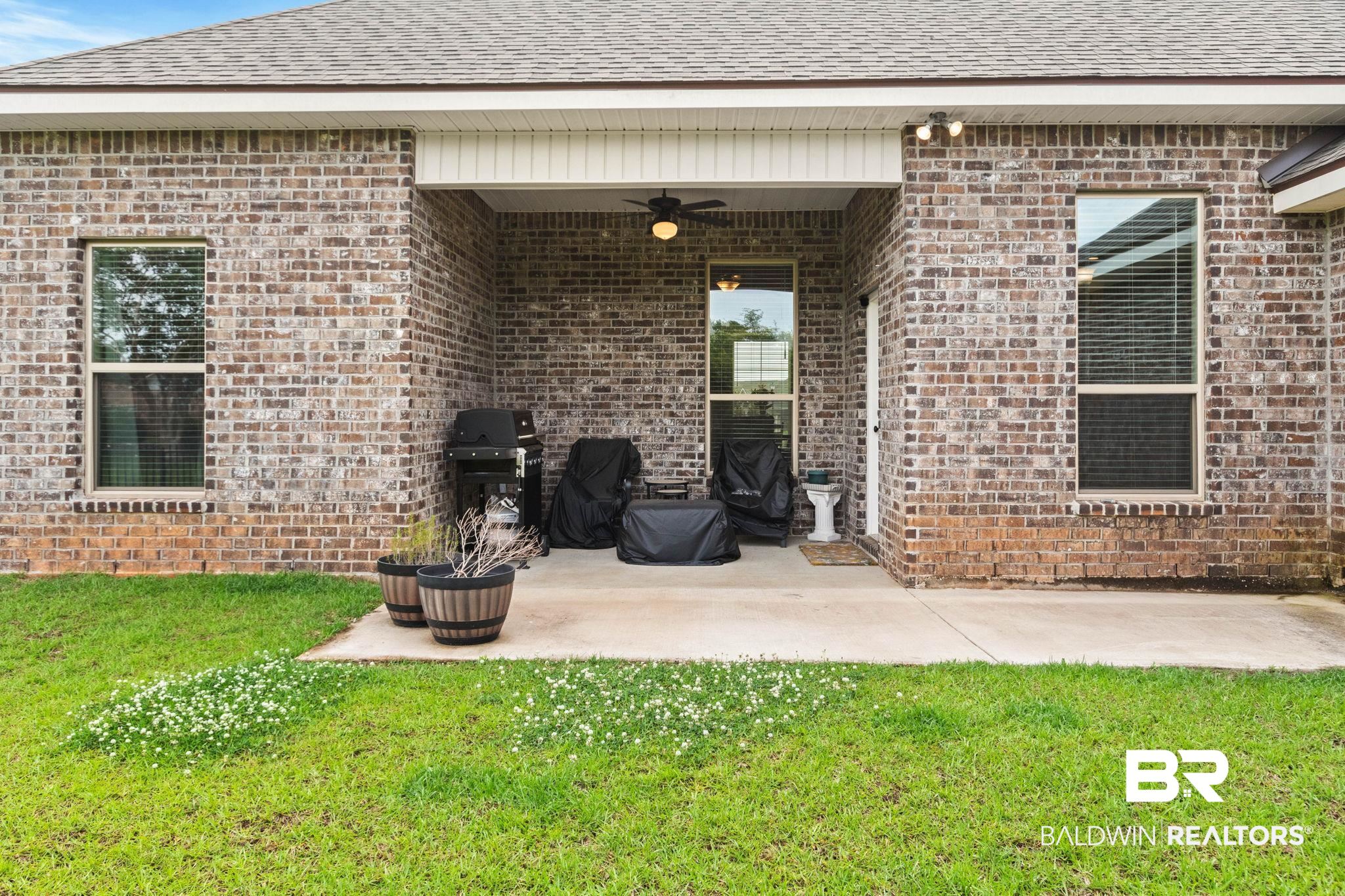 22244 Hibiscus Circle Foley, AL 36535 - Photo 10 of 51 Rear exterior featuring a covered patio with a ceiling fan, brick facade, and a shingled roof