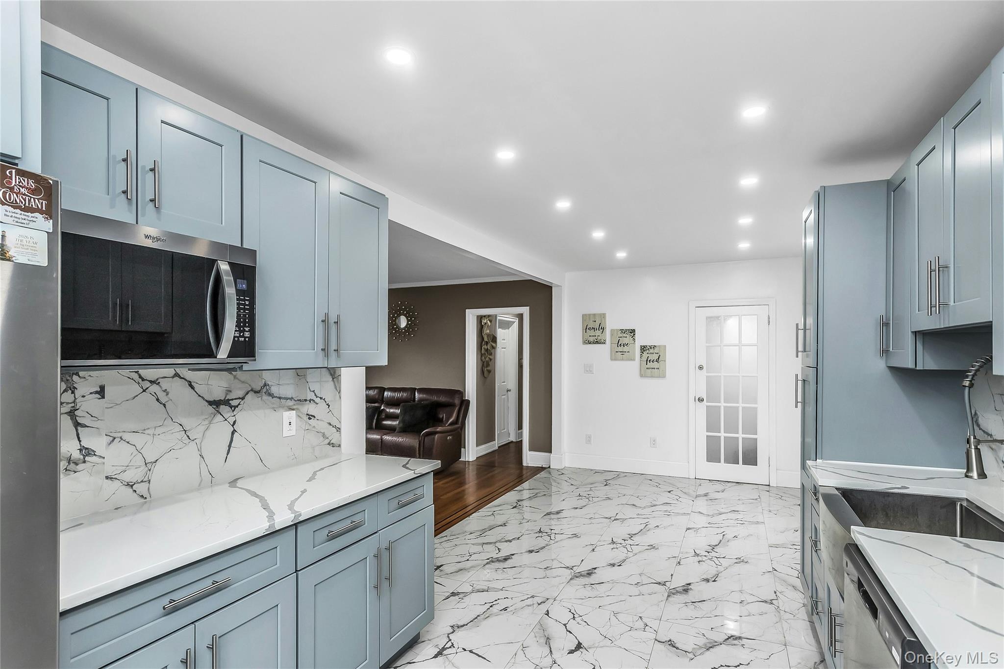 103 Union Street Valley Stream, NY 11580 - Photo 3 of 19 a kitchen with stainless steel appliances kitchen island granite countertop a refrigerator and a stove top oven