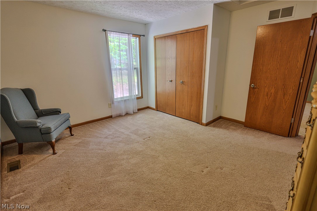 11154 Johnsford Road Southwest Beach City, OH 44608 - Photo 47 of 50 Carpeted room featuring a window with natural wood trim, wood-finish bi-fold closet doors, and additional wood-finish door