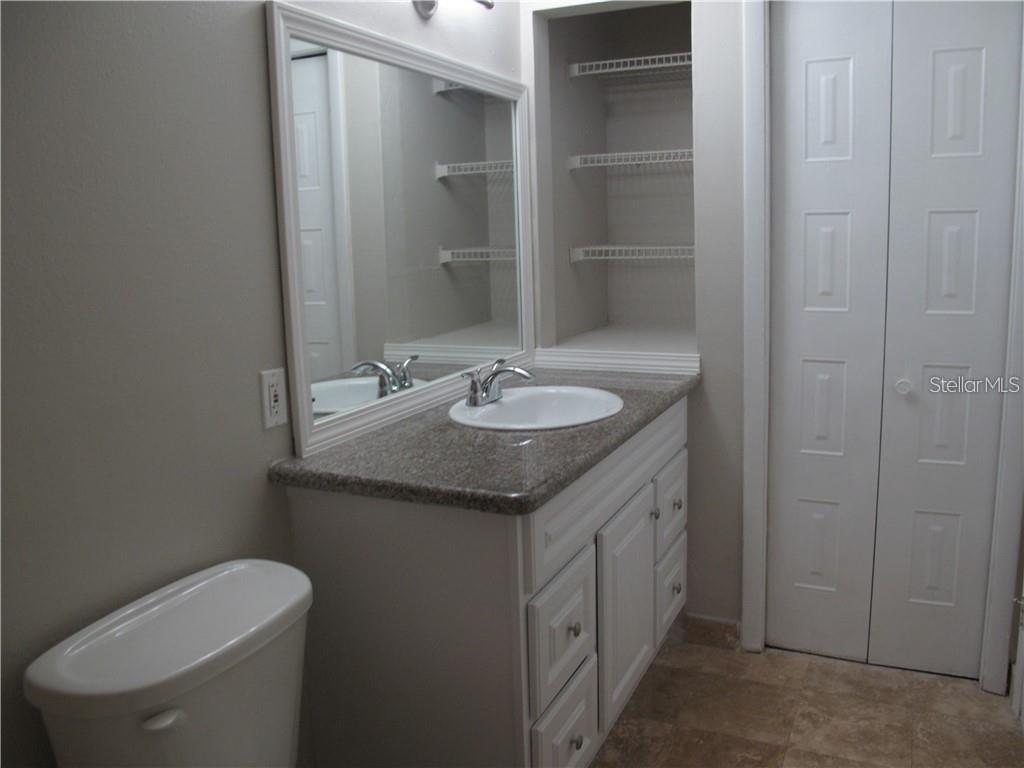 216 Afton Square, Unit 111 Altamonte Springs, FL 32714 - Photo 15 of 41 a bathroom with a granite countertop sink a toilet and a mirror