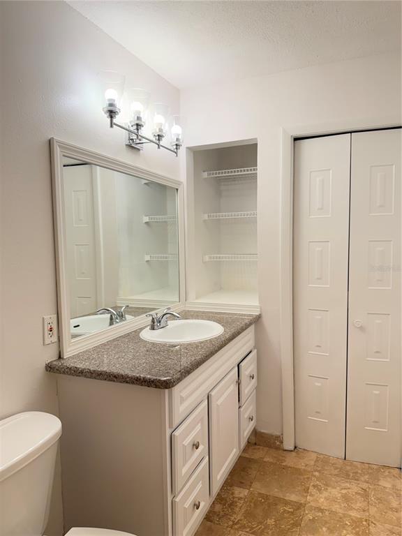 216 Afton Square, Unit 111 Altamonte Springs, FL 32714 - Photo 17 of 41 a bathroom with a granite countertop sink a toilet and a mirror