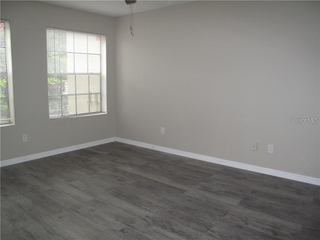 216 Afton Square, Unit 111 Altamonte Springs, FL 32714 - Photo 18 of 41 a view of an empty room with wooden floor and a window