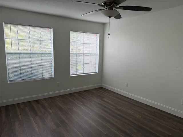 a view of an empty room with wooden floor