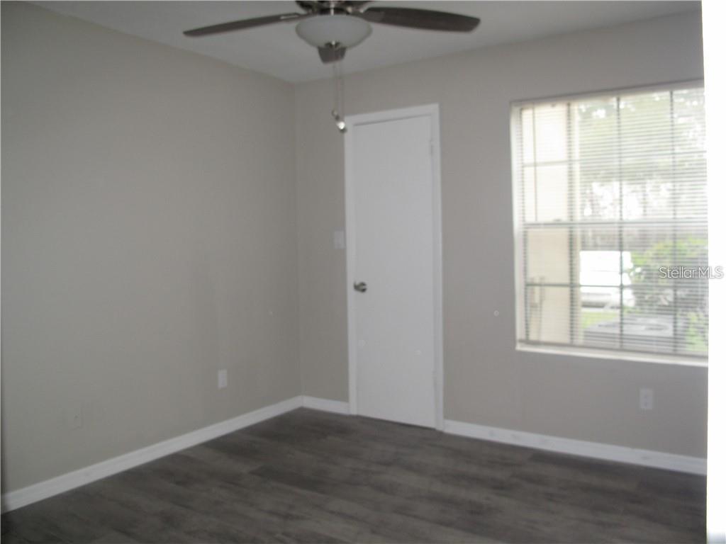 216 Afton Square, Unit 111 Altamonte Springs, FL 32714 - Photo 22 of 41 an empty room with wooden floor and windows