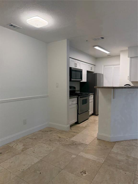 216 Afton Square, Unit 111 Altamonte Springs, FL 32714 - Photo 7 of 41 a kitchen with a refrigerator and a sink