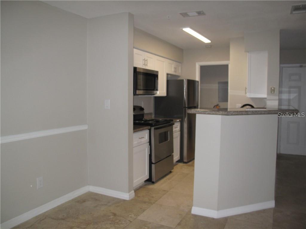 216 Afton Square, Unit 111 Altamonte Springs, FL 32714 - Photo 9 of 41 a kitchen with a refrigerator and a stove top oven