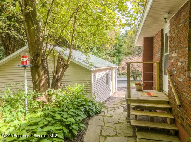 a view of a house with a yard and large trees