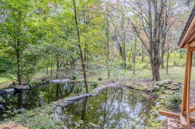a front view of house with yard and trees in the background