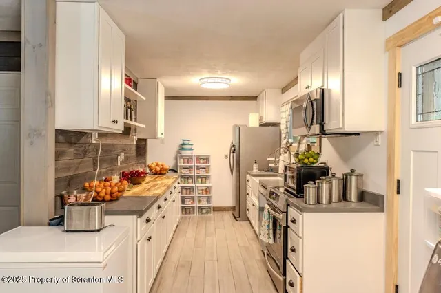a kitchen with stainless steel appliances a stove refrigerator sink and a microwave