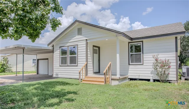 a front view of a house with a garden