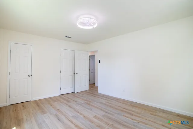 a view of an empty room with wooden floor
