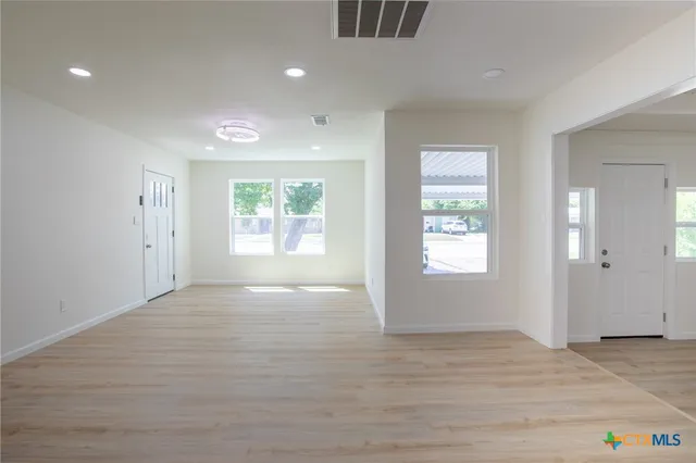 an empty room with windows and closet