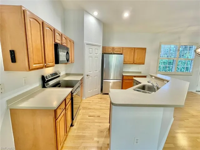 a white refrigerator freezer and a stove sitting inside of a kitchen