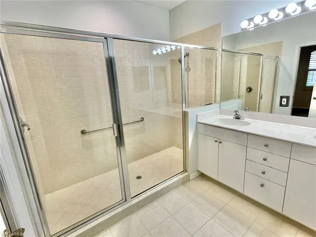 a bathroom with a shower sink and mirror