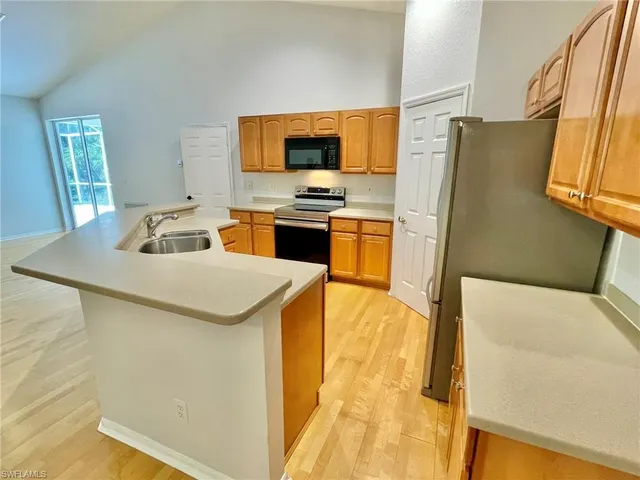 a kitchen with stainless steel appliances a refrigerator and a stove top oven
