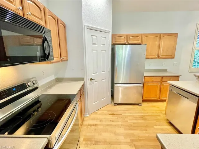 a kitchen with stainless steel appliances granite countertop a sink refrigerator and microwave