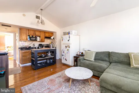 a living room with furniture and a dining table with kitchen view