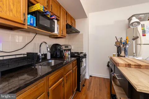 a kitchen with granite countertop a sink a stove and cabinets
