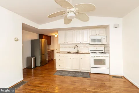 a kitchen with stainless steel appliances a stove a refrigerator and white cabinets