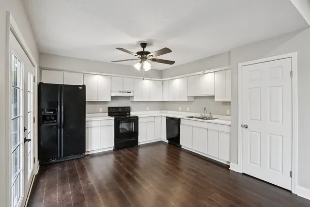 a kitchen with a refrigerator and a stove top oven