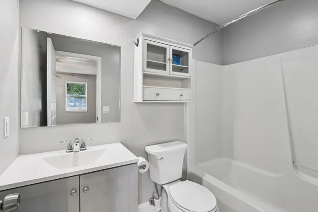 a bathroom with a sink toilet a mirror and shower