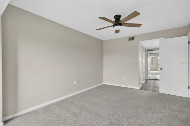 an empty room with a window and a fan