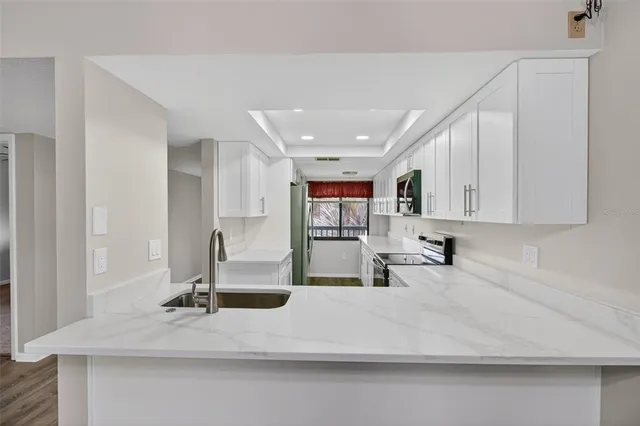 a view of a kitchen with kitchen island a sink wooden floor and counter top space