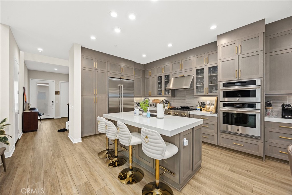 478 Sycamore Montebello, CA 90640 - Photo 14 of 67 a kitchen with stainless steel appliances a sink a stove a refrigerator cabinets and wooden floor