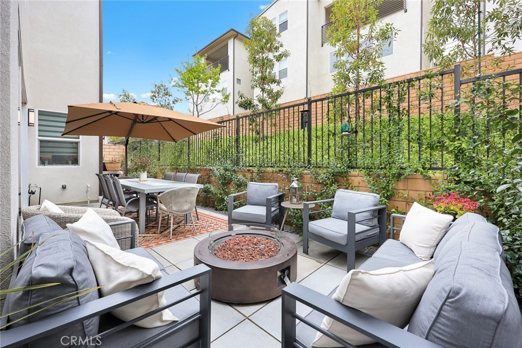 478 Sycamore Montebello, CA 90640 - Photo 44 of 67 a view of a patio with couches table and chairs under an umbrella with a fire pit