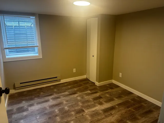 a view of a room with wooden floor and a window