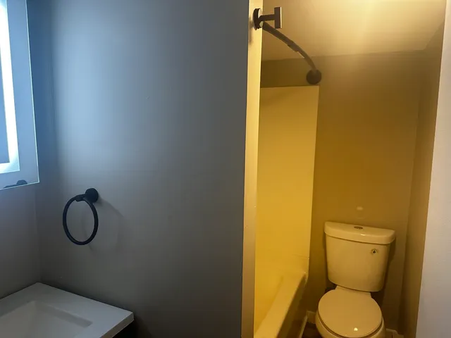 a white toilet sitting next to a bathroom sink
