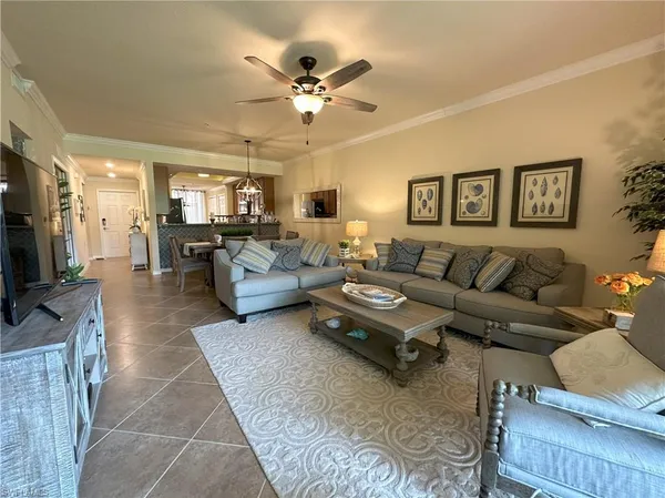 a living room with furniture kitchen view and a flat screen tv