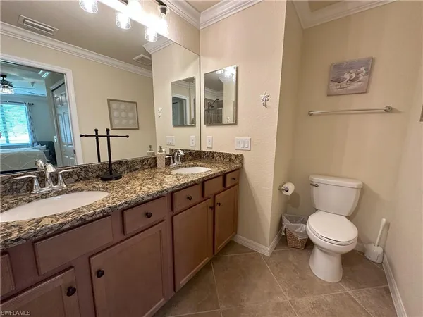 a bathroom with a granite countertop toilet sink and mirror