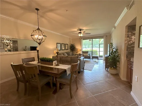 a view of a dining room and livingroom furniture wooden floor a rug and a chandelier