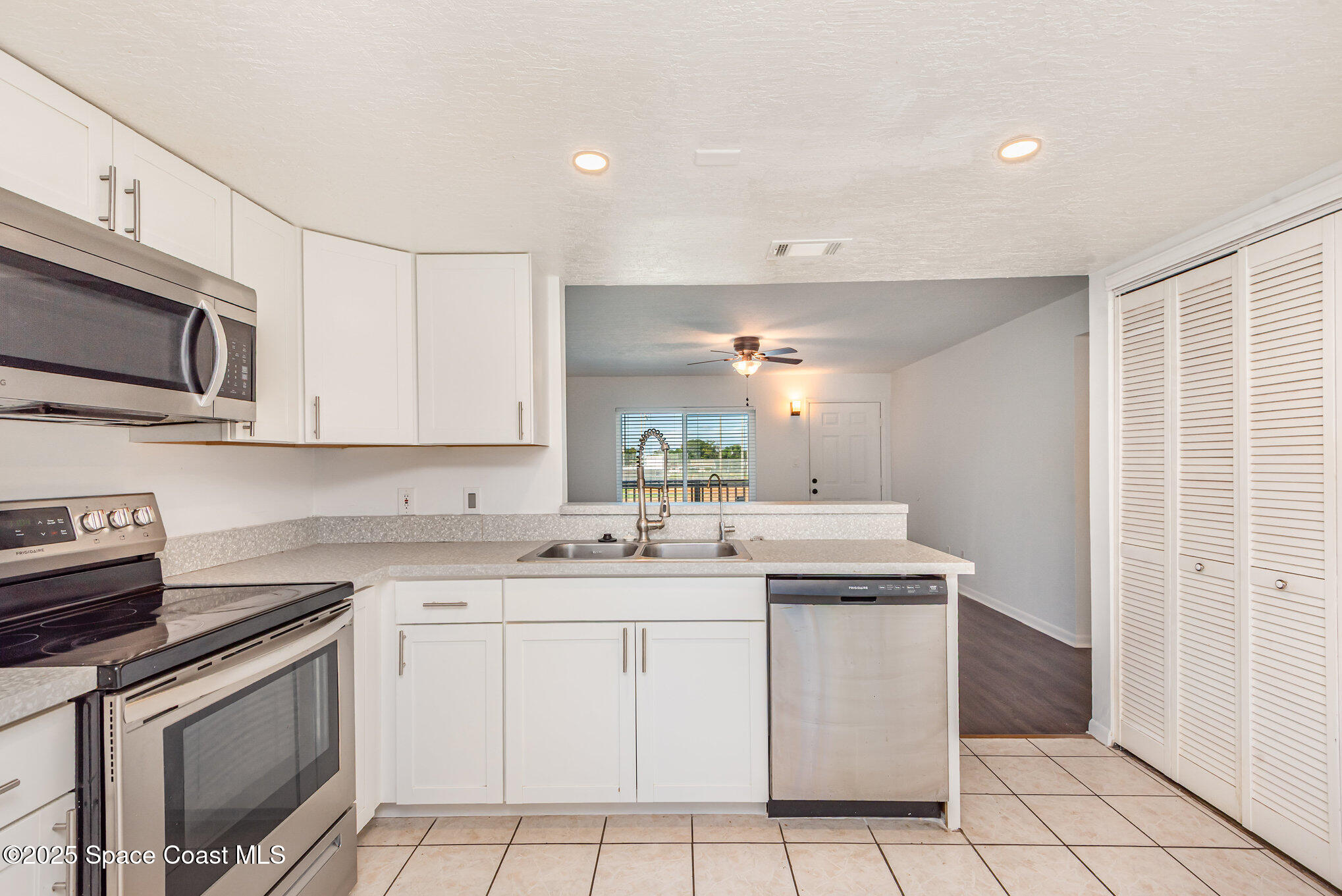 1515 Huntington Lane, Unit 427 Rockledge, FL 32955 - Photo 9 of 21 a kitchen with stainless steel appliances granite countertop a sink stove top oven and microwave