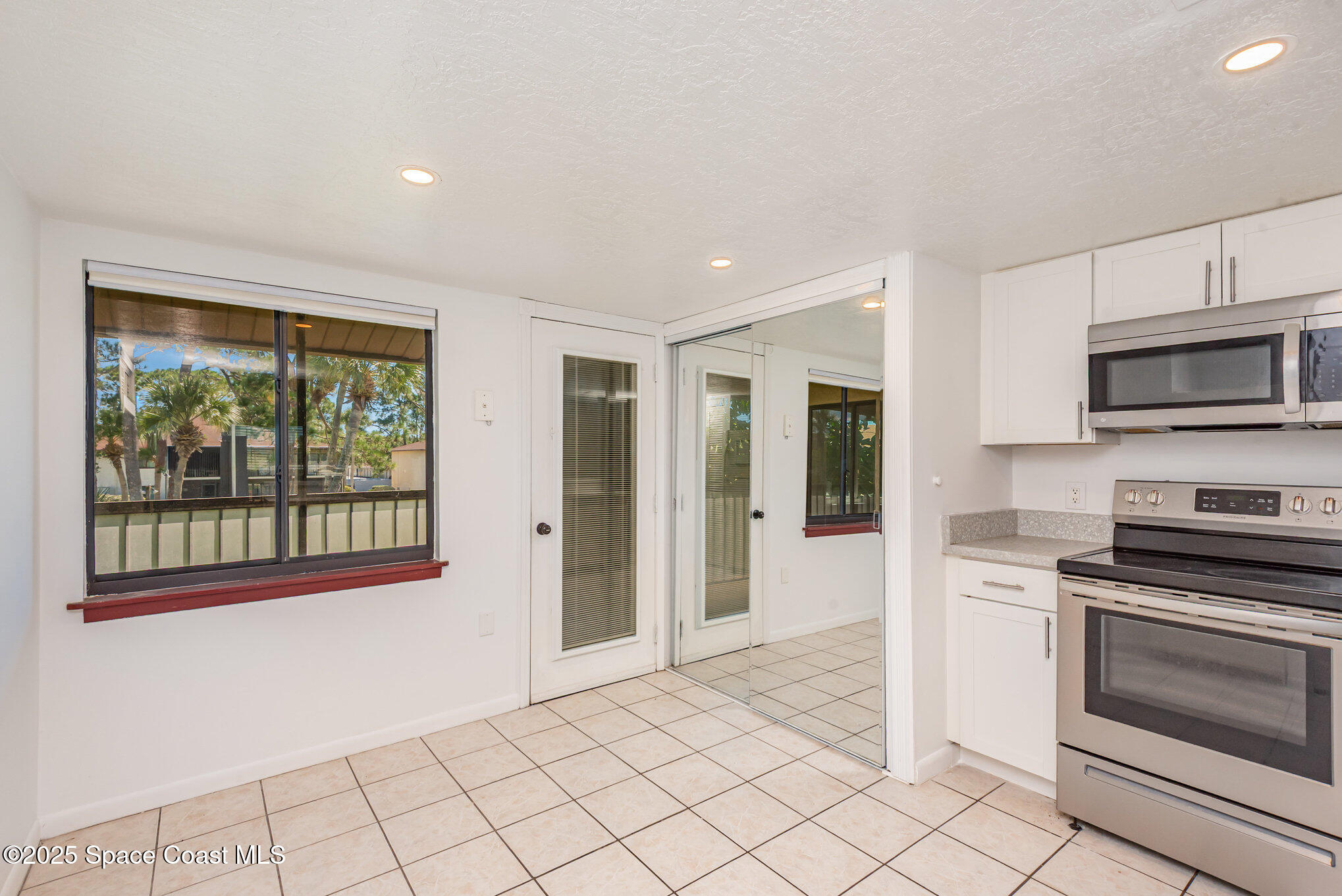 1515 Huntington Lane, Unit 427 Rockledge, FL 32955 - Photo 10 of 21 a kitchen with granite countertop a stove and a microwave