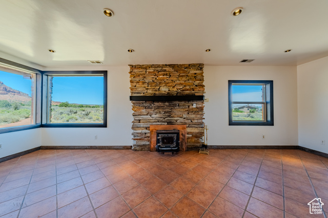 6178 East Zion Road Kanab, UT 84741 - Photo 11 of 48 Unfurnished living room with tile patterned flooring, a wood stove, and recessed lighting