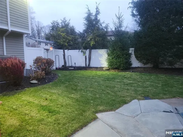 a backyard of a house with lots of green space and fountain